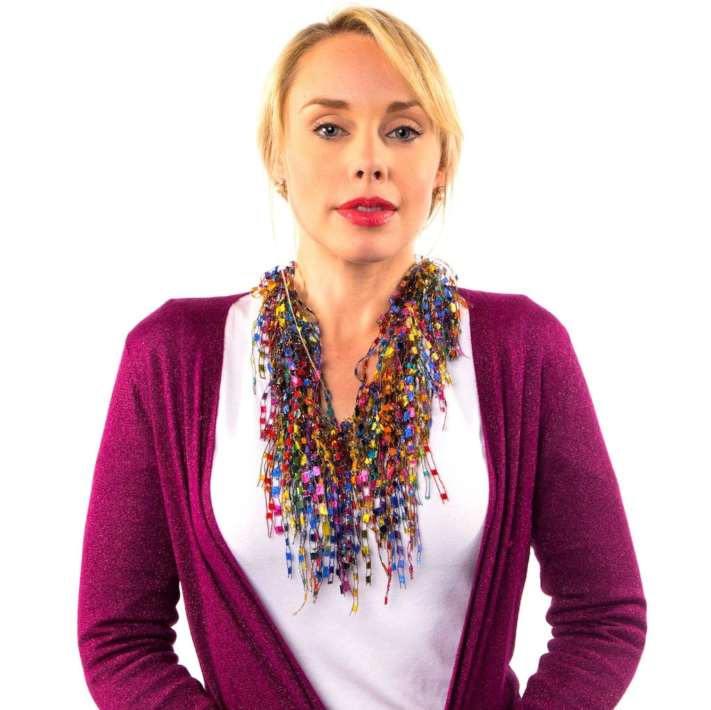 colorful scarf necklace for women worn by women with a white top and complementing pink sweater